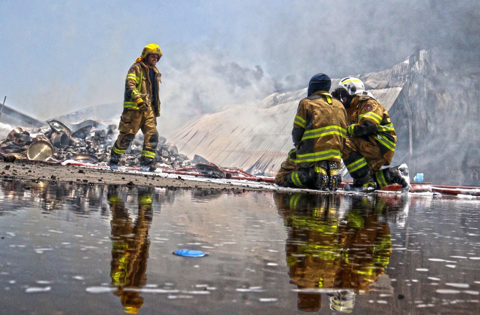 6月19日，消防人員在科威特首都省一處倉庫火災現場滅火。（新華社）