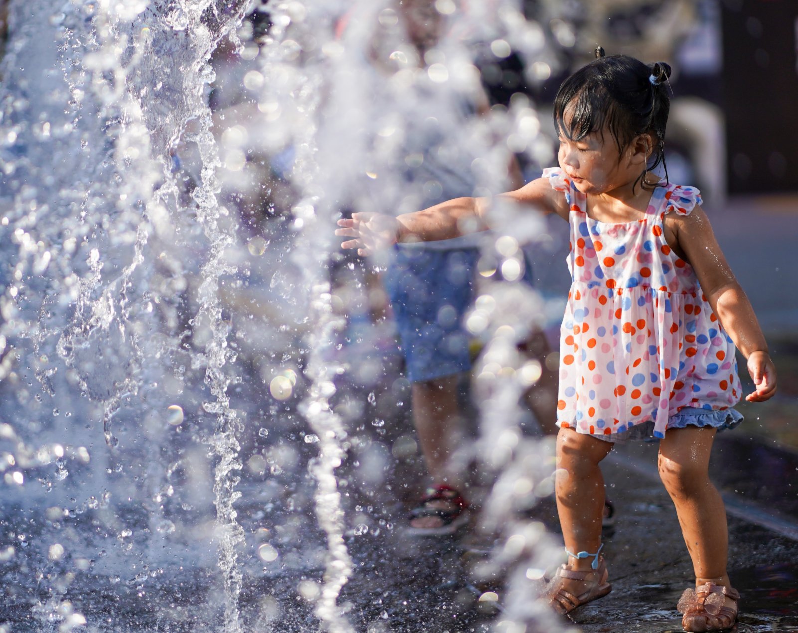 6月20日，小女孩在北京華熙LIVE·五棵松商業街區一處噴泉戲水。（新華社）
