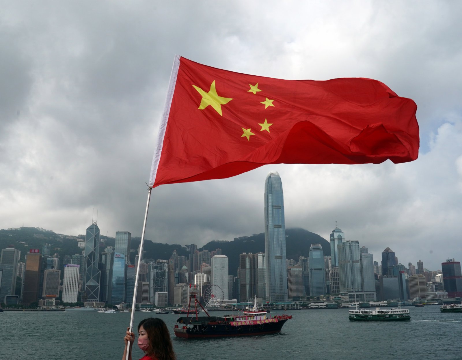 7月1日，在香港尖沙咀，香港市民揮舞國旗慶祝。（新華社）