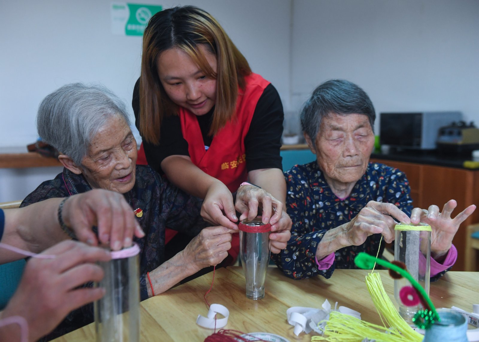 7月2日，在杭州市臨安區社會福利中心，老人們在志願者的指導下參加手工製作課。（新華社）