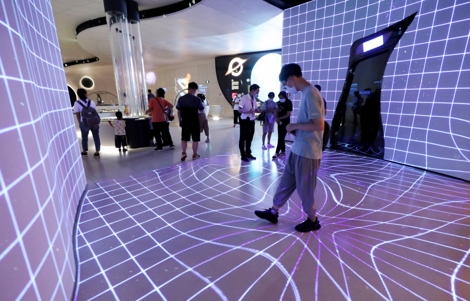 參觀者在體驗由投影裝置模擬的引力波。