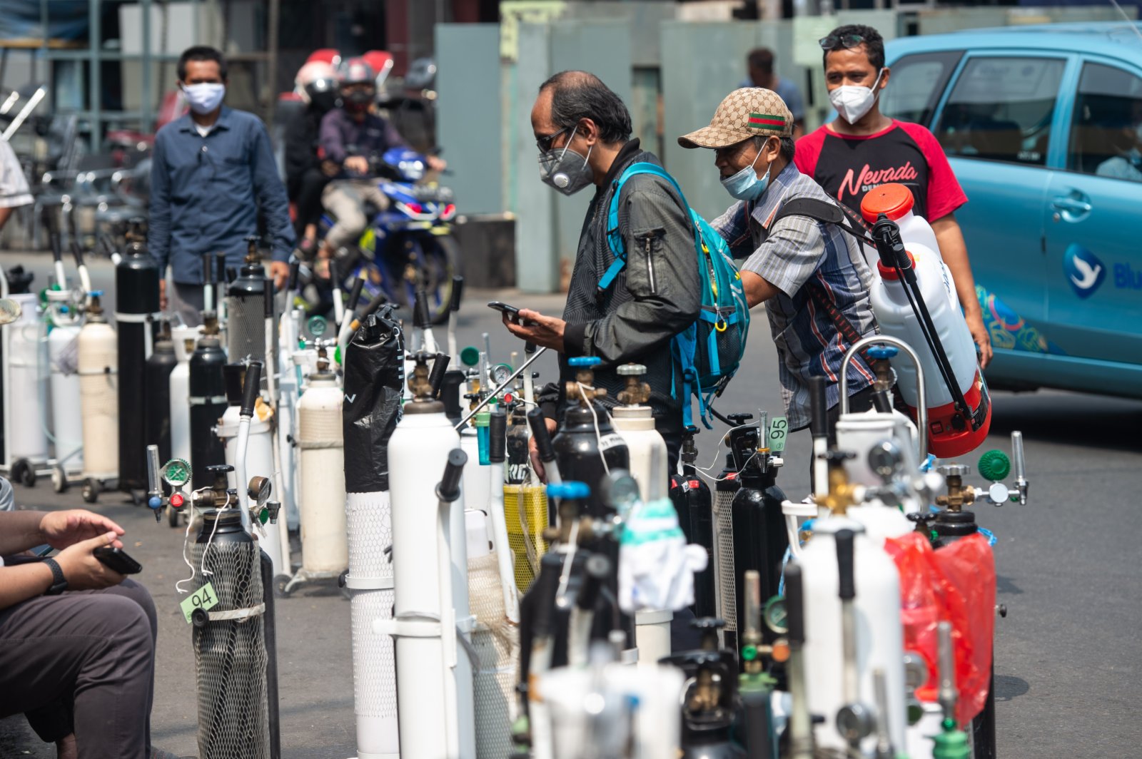 7月5日，人們在印度尼西亞雅加達排隊給氧氣罐充氧。（新華社）