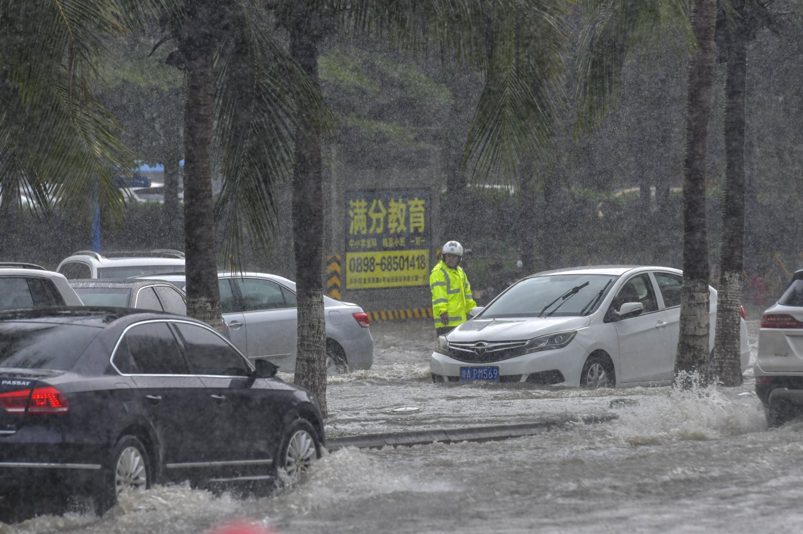 海口港附近道路出現嚴重積水，交警在現場指揮車輛通過積水路段。