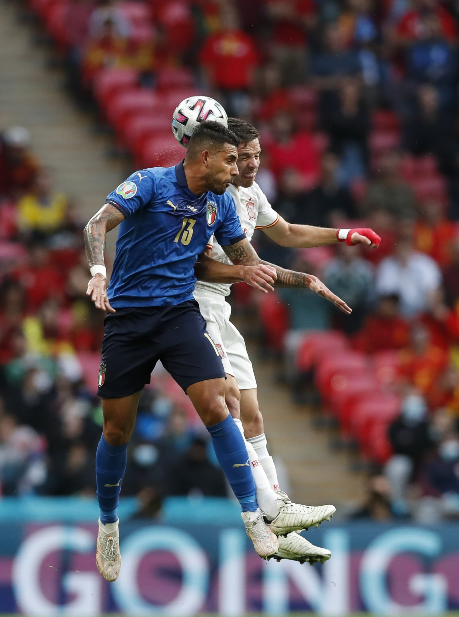 意大利隊球員埃莫森（左）與西班牙隊球員爭頂頭球。新華社