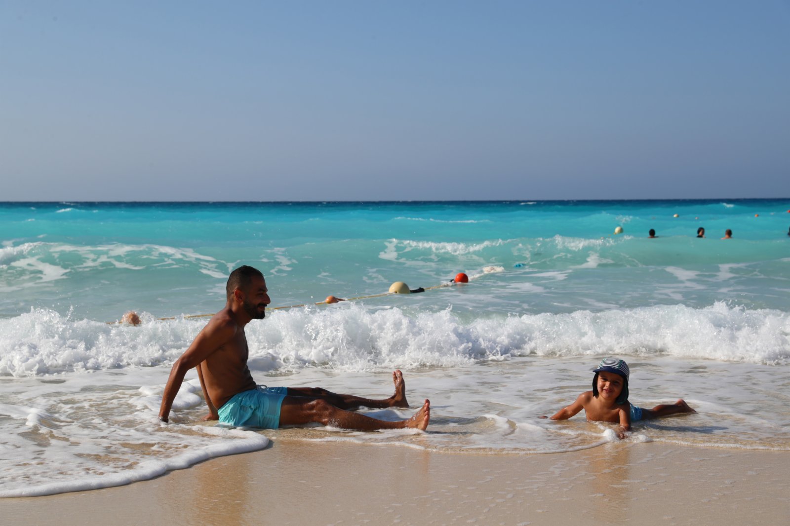 7月17日，一名男子帶着孩子在埃及馬特魯省阿拉曼的海灘上休閒。（新華社）