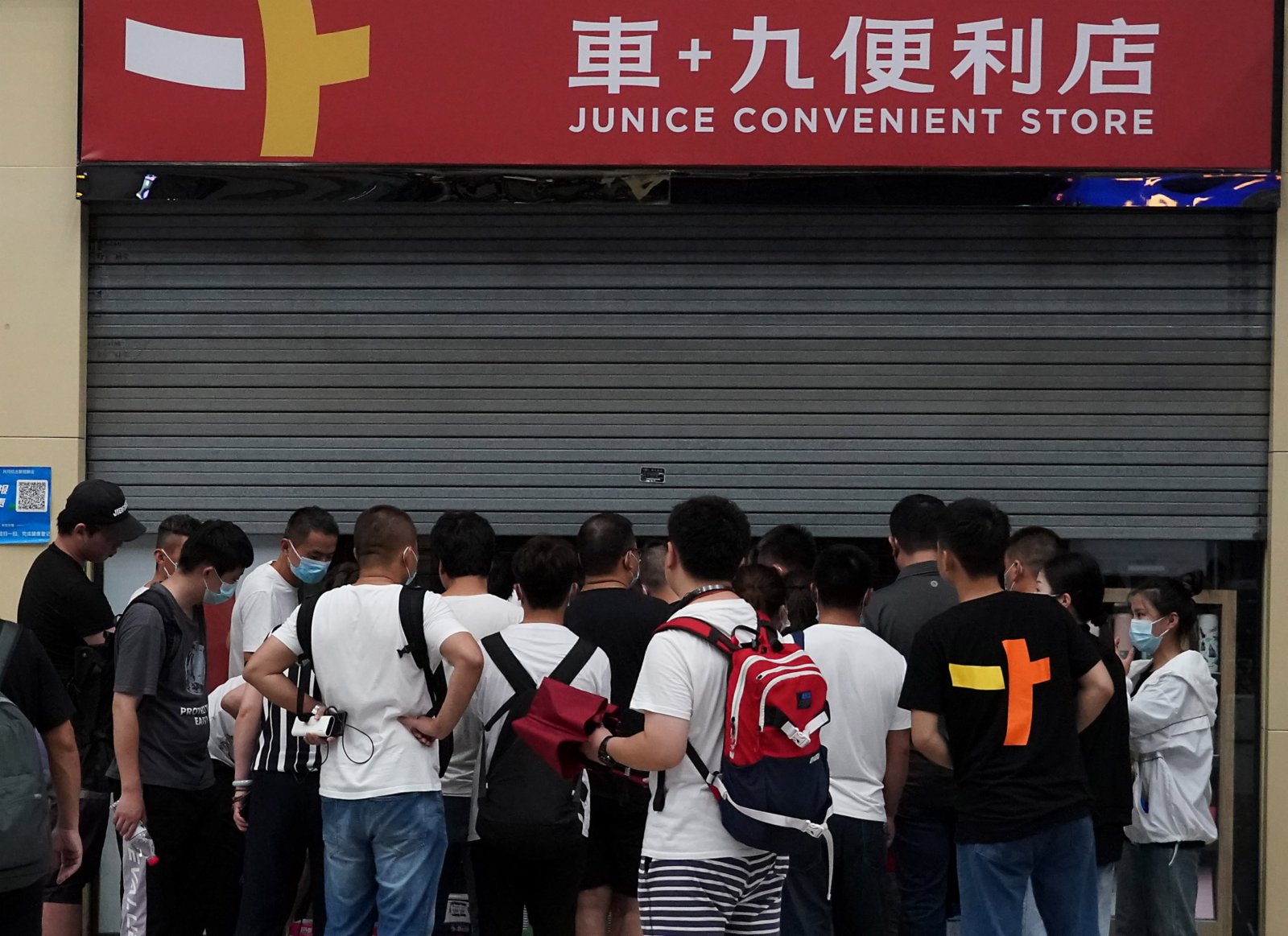 7月20日，滯留旅客在鄭州東站一家便利店外排隊購物。（新華社）