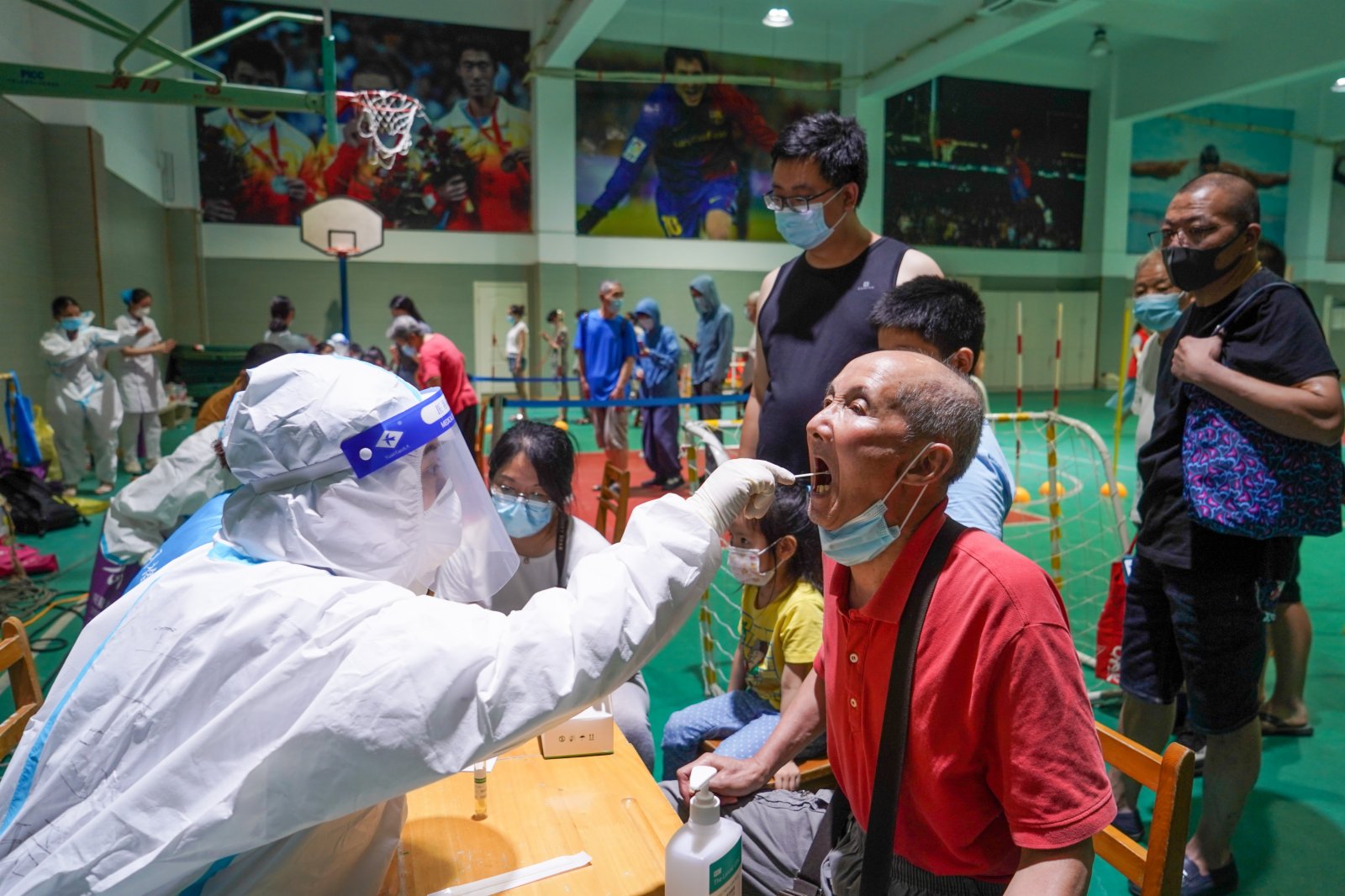 7月21日晚，在南京市建鄴區一處檢測點，醫務人員在為市民進行核酸檢測取樣。（新華社）