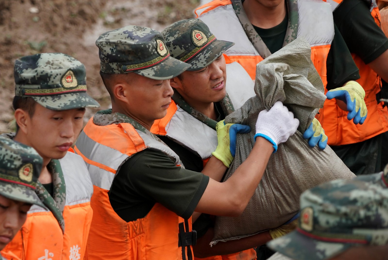 7月29日，救援人員在浚縣傅莊堤上搬運沙袋，加固大堤。（新華社）