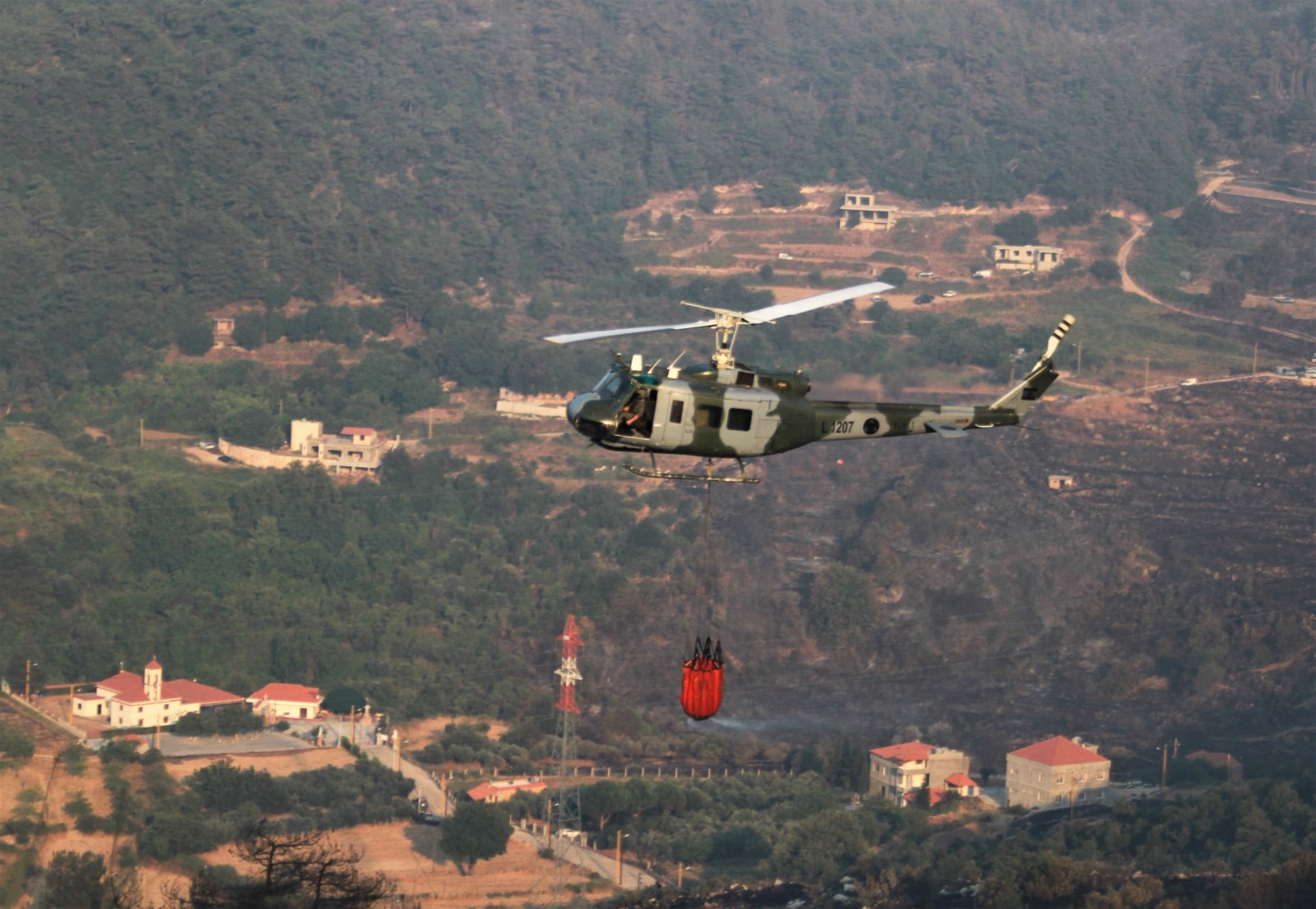 7月29日，黎巴嫩軍方直升機在阿卡爾省火災現場參與滅火行動。（新華社）