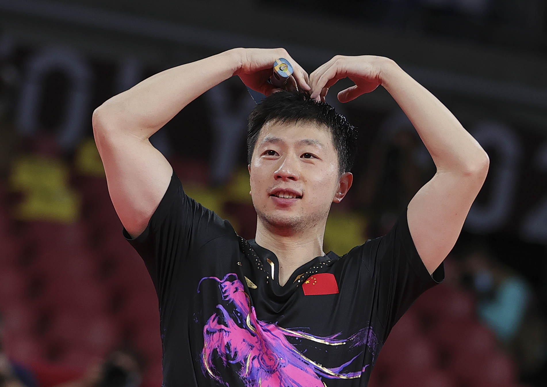 7月30日，中國選手馬龍在乒乓球男子單打決賽後「比心」慶祝衛冕。