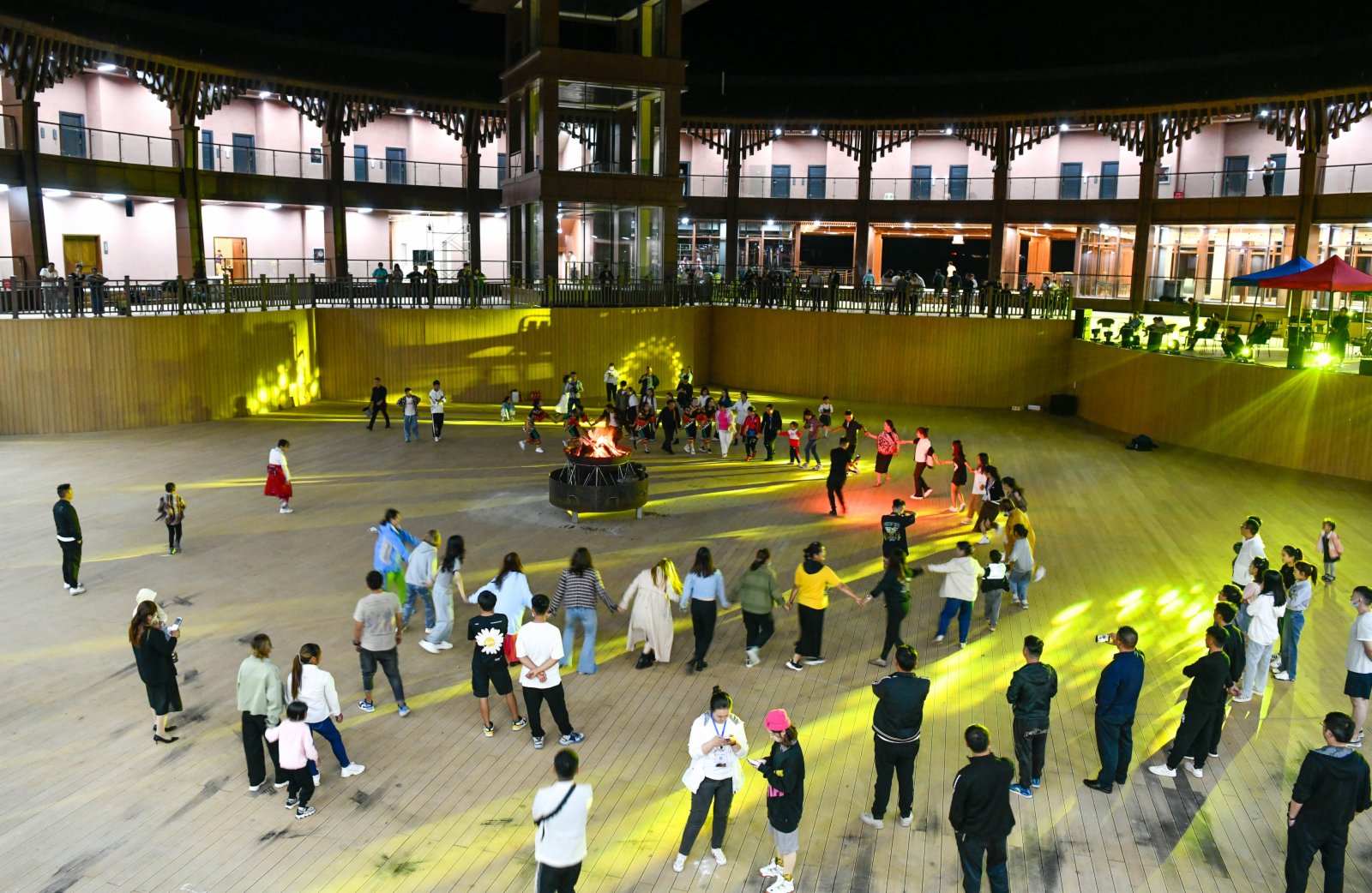 9月3日，遊客在貴州省赫章縣阿西里西·二台坡景區與演員圍着篝火跳民族舞蹈。（新華社）