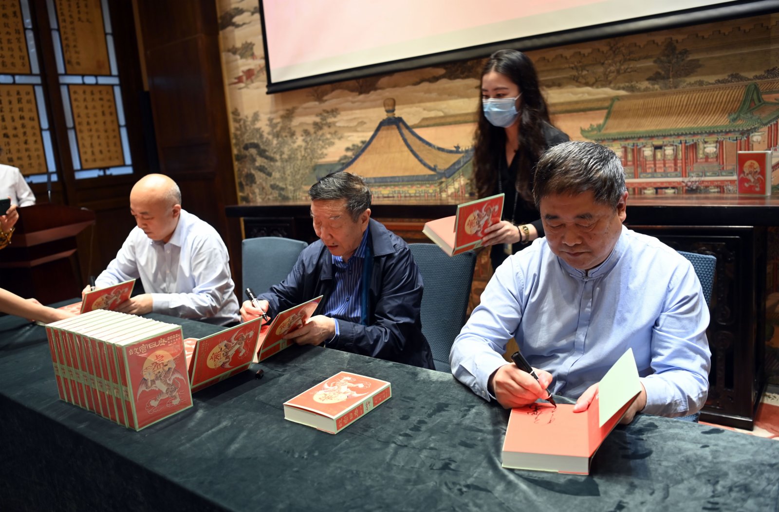 9月6日，故宮博物院院長王旭東（左一），故宮博物院原院長鄭欣淼（左二）、故宮博物院原院長單霽翔（右一）在2022年《故宮日曆》上簽名。