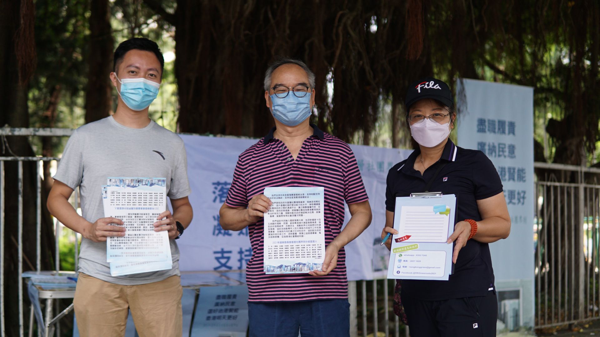 基層社團界別分組選委李梓敬(左一)、前民政事務局局長劉江華(左二)在大圍金獅花園對開街站。 基層社團界別分組選委李梓敬(左一)、前民政事務局局長劉江華(左二)在大圍金獅花園對開街站。