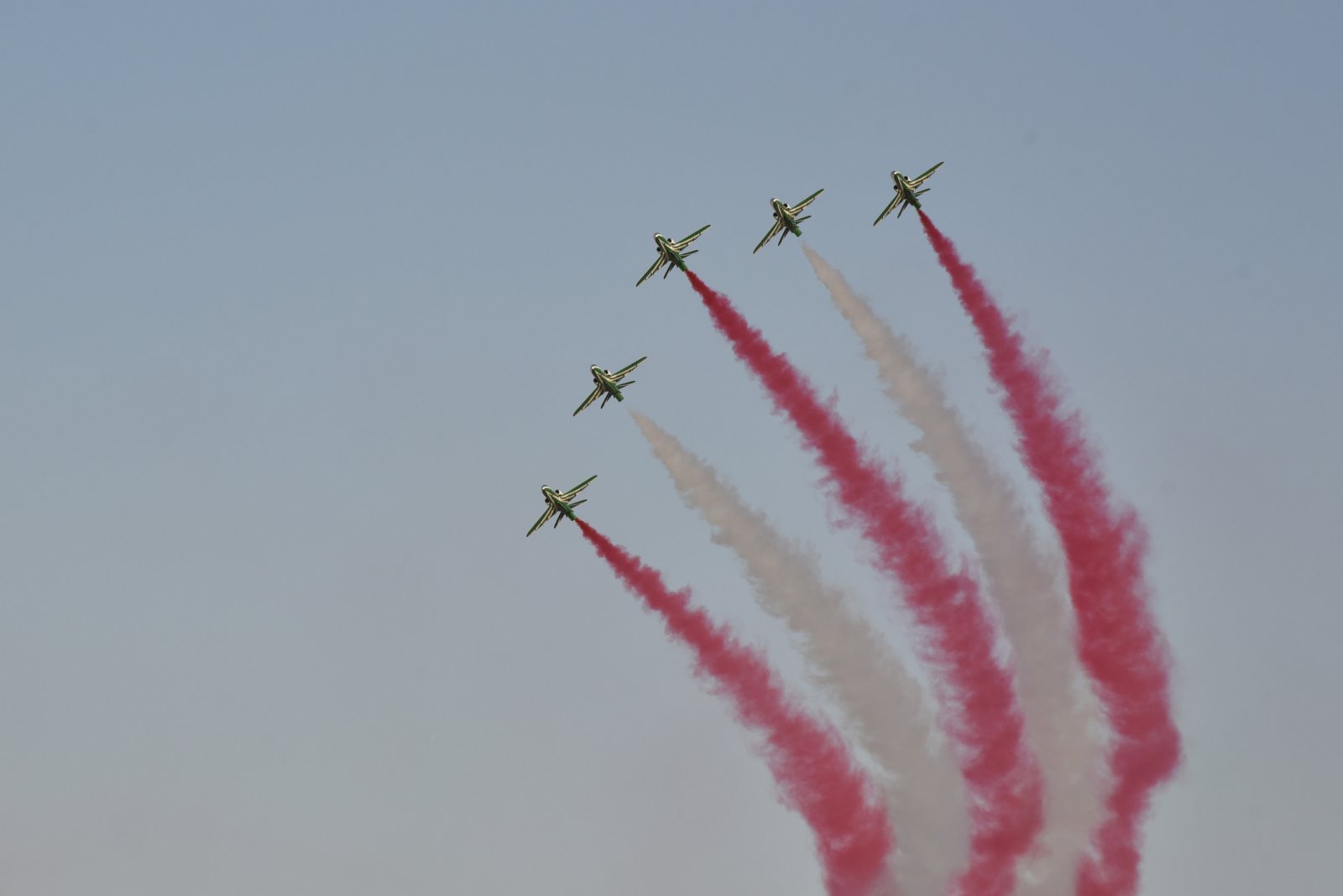 9月22日，在沙特阿拉伯首都利雅得，五架飛機在天空中噴射彩煙，並作出特技動作。（新華社）