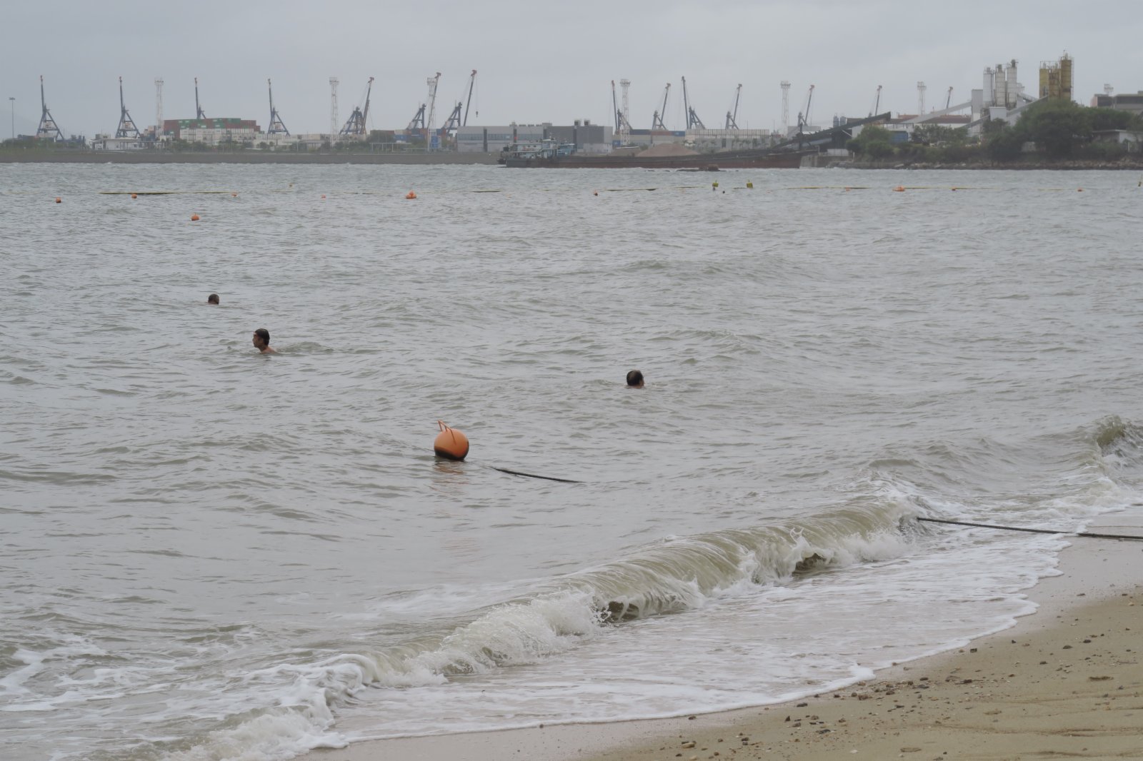 圖為有市民在八號風球下到屯門蝴蝶泳灘游泳。（中新社）