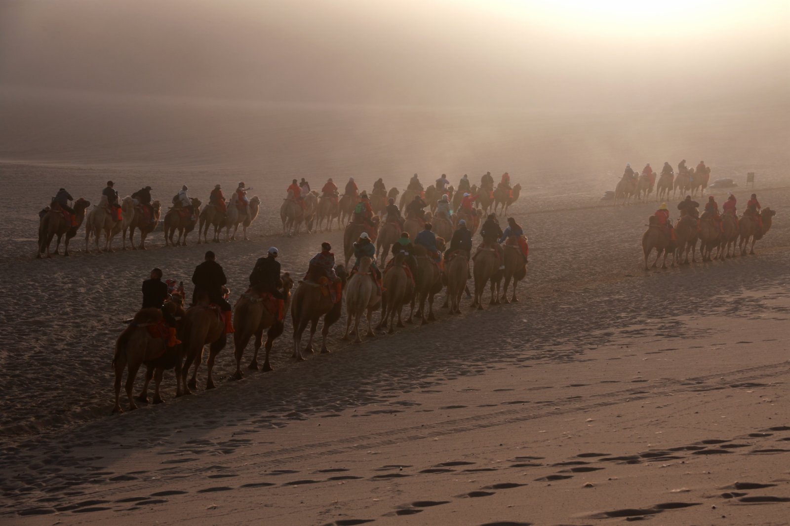 10月17日，遊客在甘肅省敦煌市鳴沙山月牙泉景區騎駱駝遊覽。（新華社）