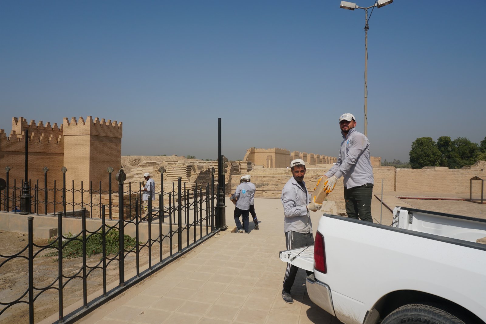 10月16日，文物修復人員在伊拉克巴比倫古城遺址搬運材料。（新華社）