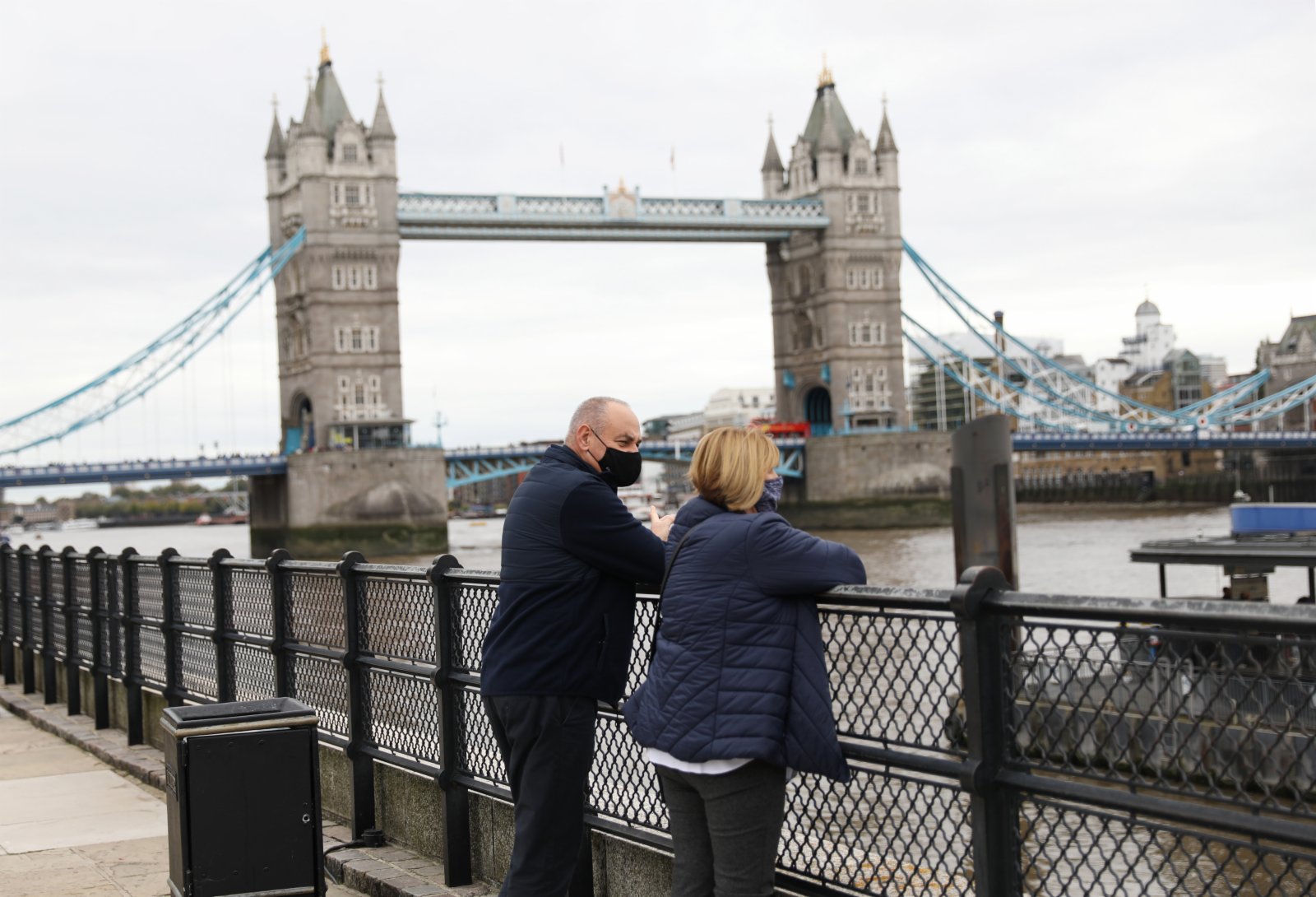 10月23日，人們戴着口罩在英國倫敦塔橋旁休閒。