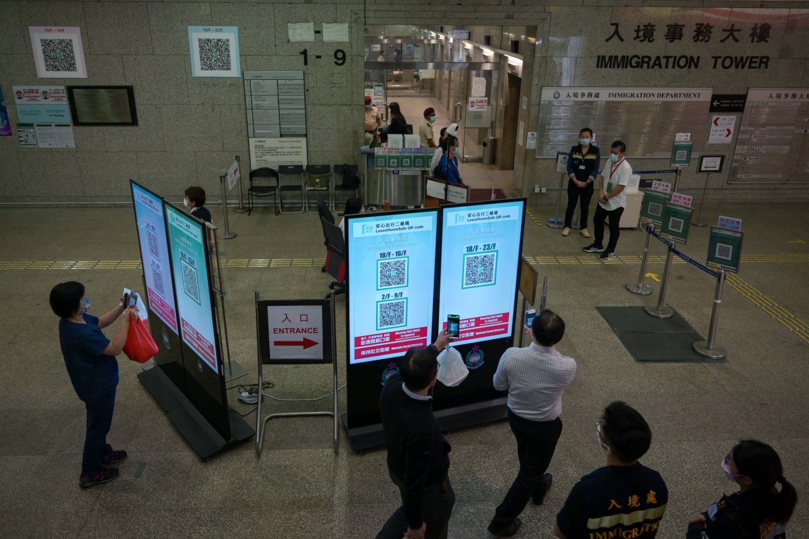 市民在進入入境事務大樓前掃「安心出行」二維碼。（中新社）