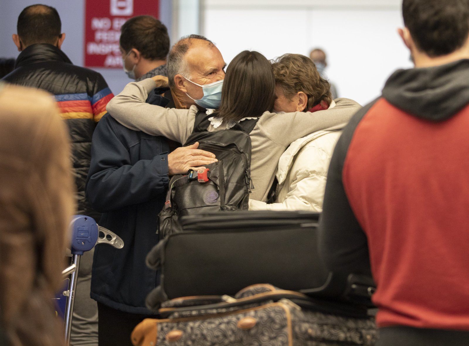 當地時間11月8日，一位女士在美國加州舊金山國際機場的國際航班到達區域擁抱來自法國的父母。（中新社）