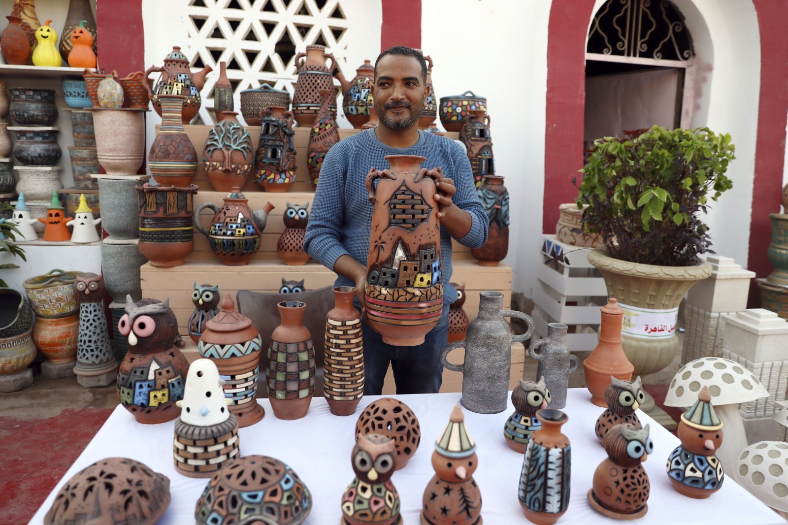 11月6日，一位制陶手藝人在埃及開羅制陶村舉辦的陶器展上展示陶器製品。（新華社）
