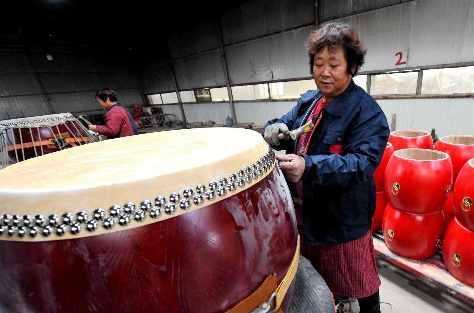 11月17日，在饒陽縣好望角民族樂器產業園一家企業的車間內，工人在為鼓蒙皮。（新華社）