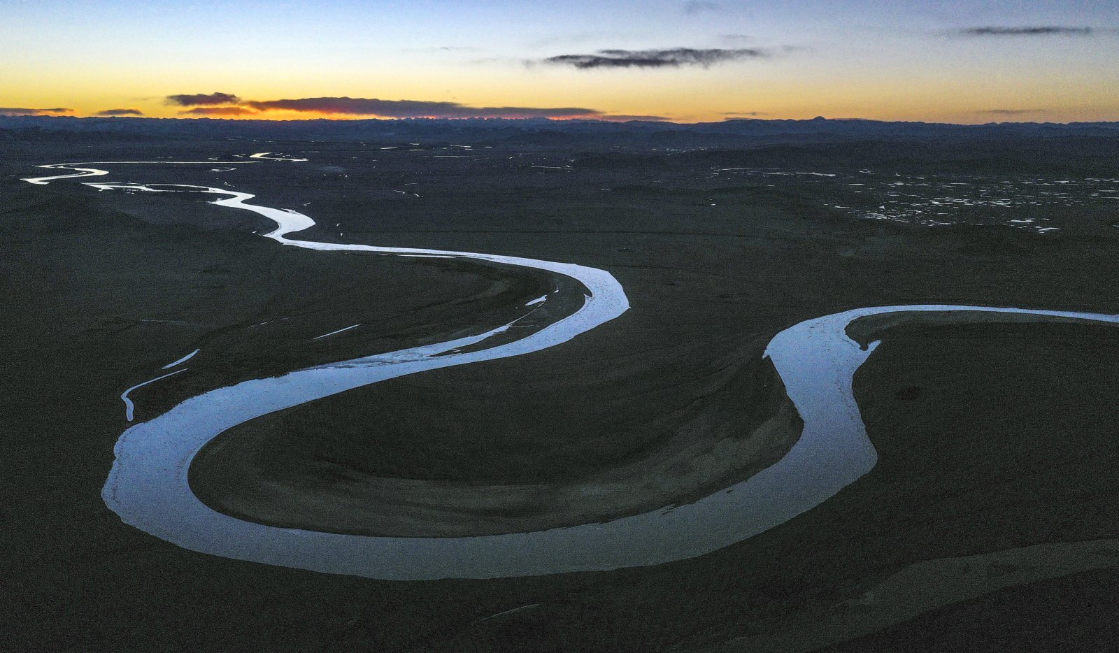 11月24日，在四川省阿壩藏族羌族自治州若爾蓋縣，黃河在落日餘暉映照下壯美如畫（無人機照片）。