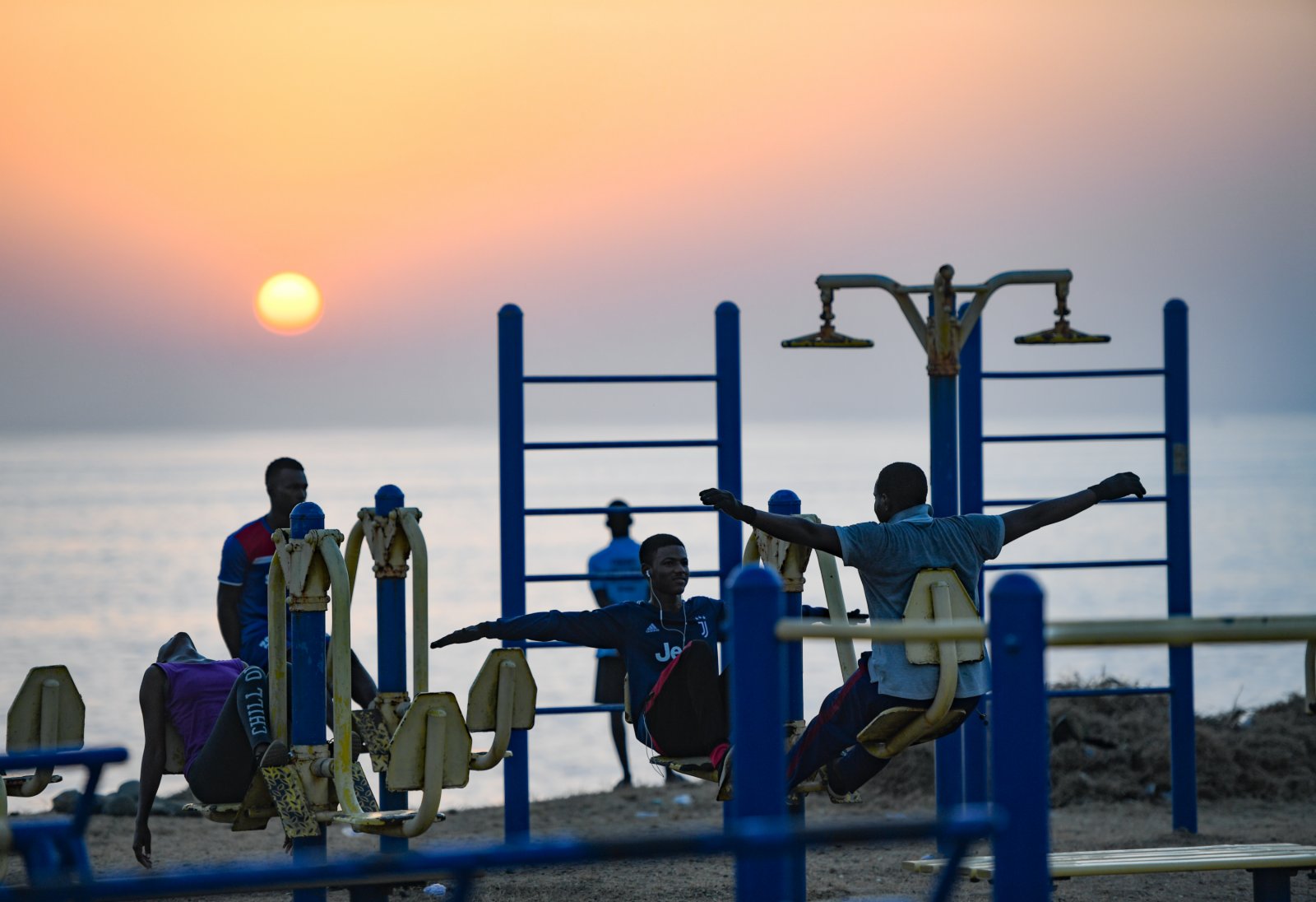 11月24日，人們在塞內加爾首都達喀爾的海邊使用健身器械。（新華社）