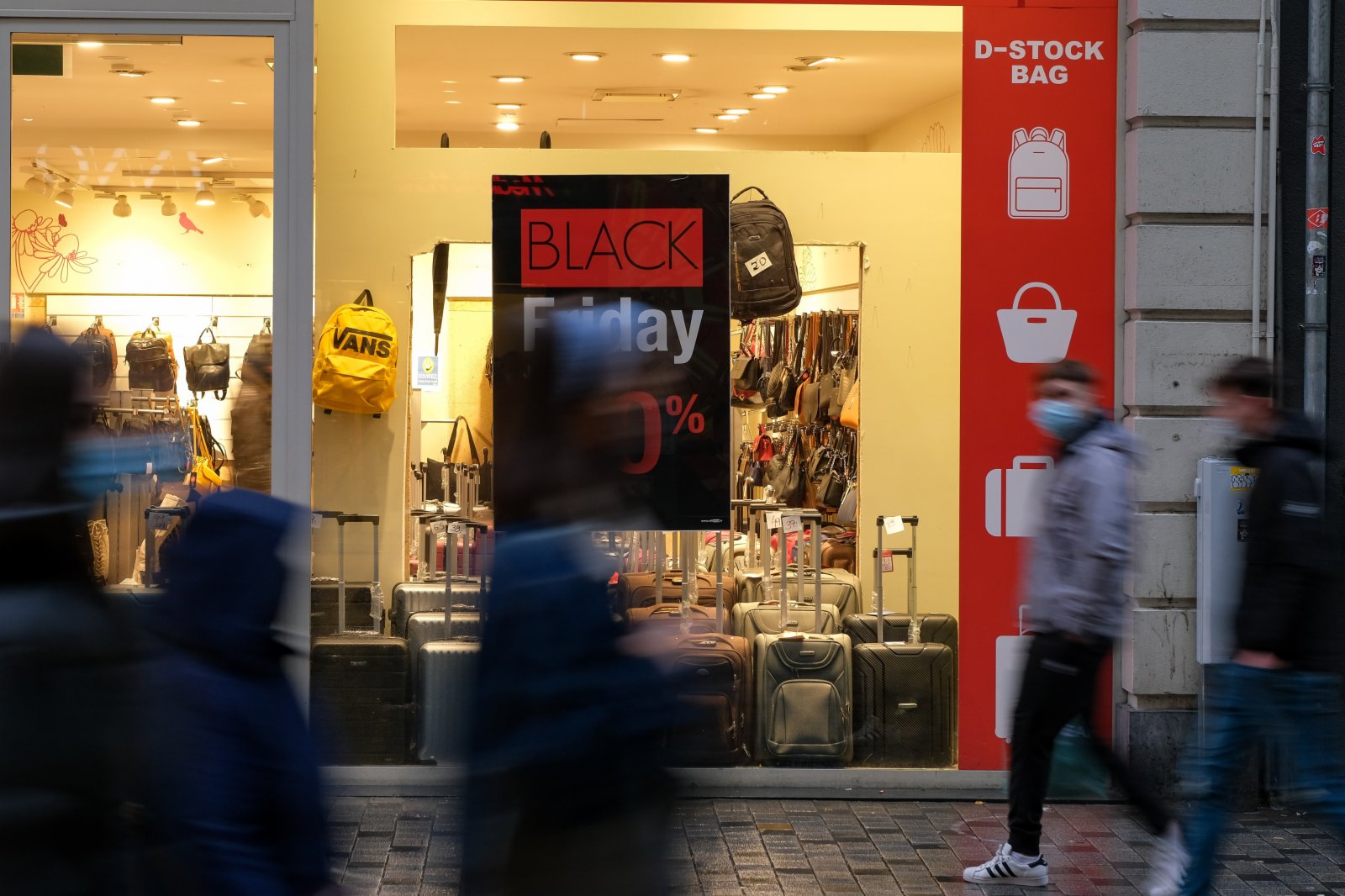 11月26日，人們走過比利時布魯塞爾街頭一處「黑色星期五」購物促銷廣告。（新華社）