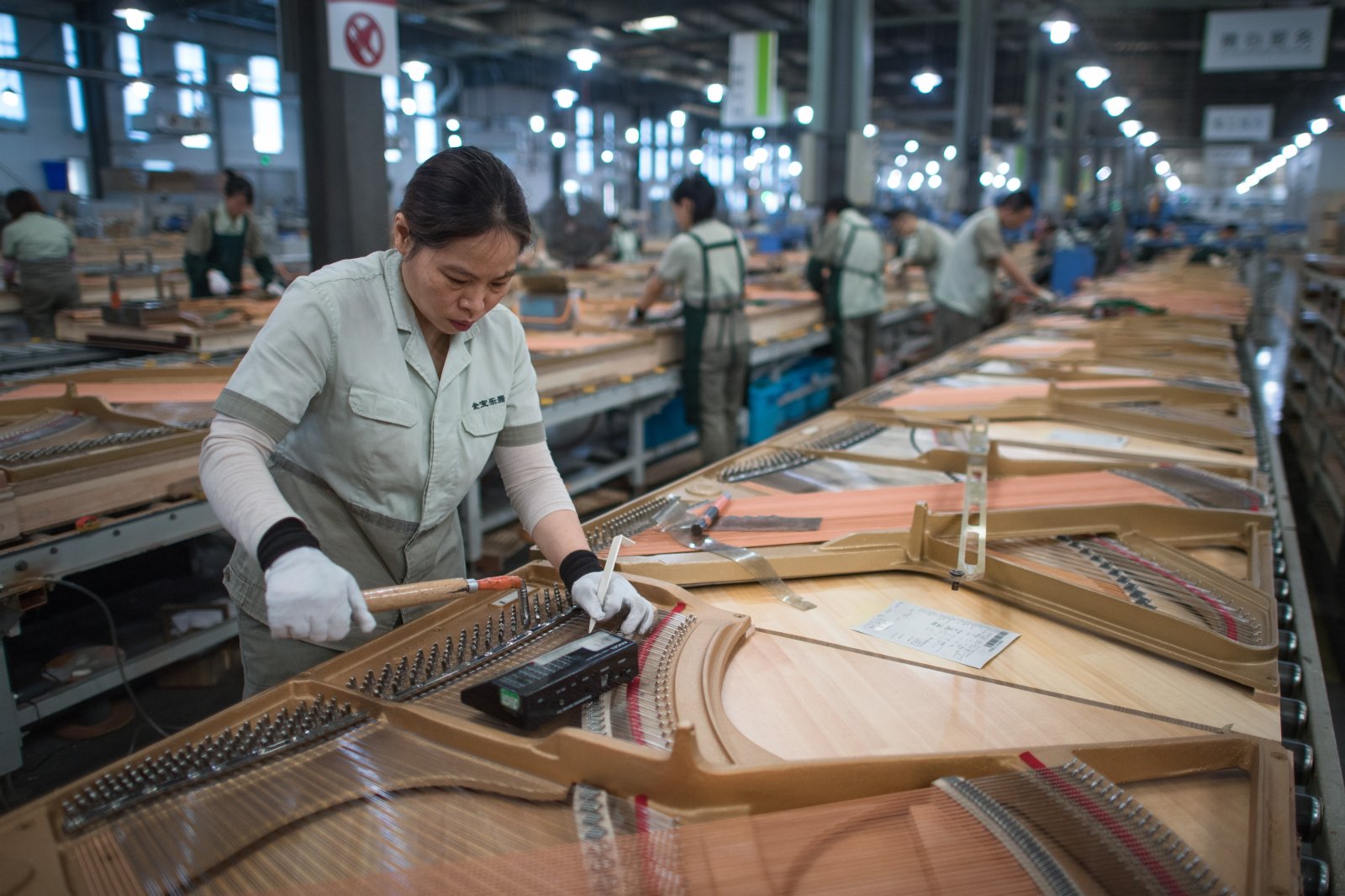 工人在柏斯音樂集團宜昌鋼琴生產基地進行鋼琴部件安裝。（新華社）