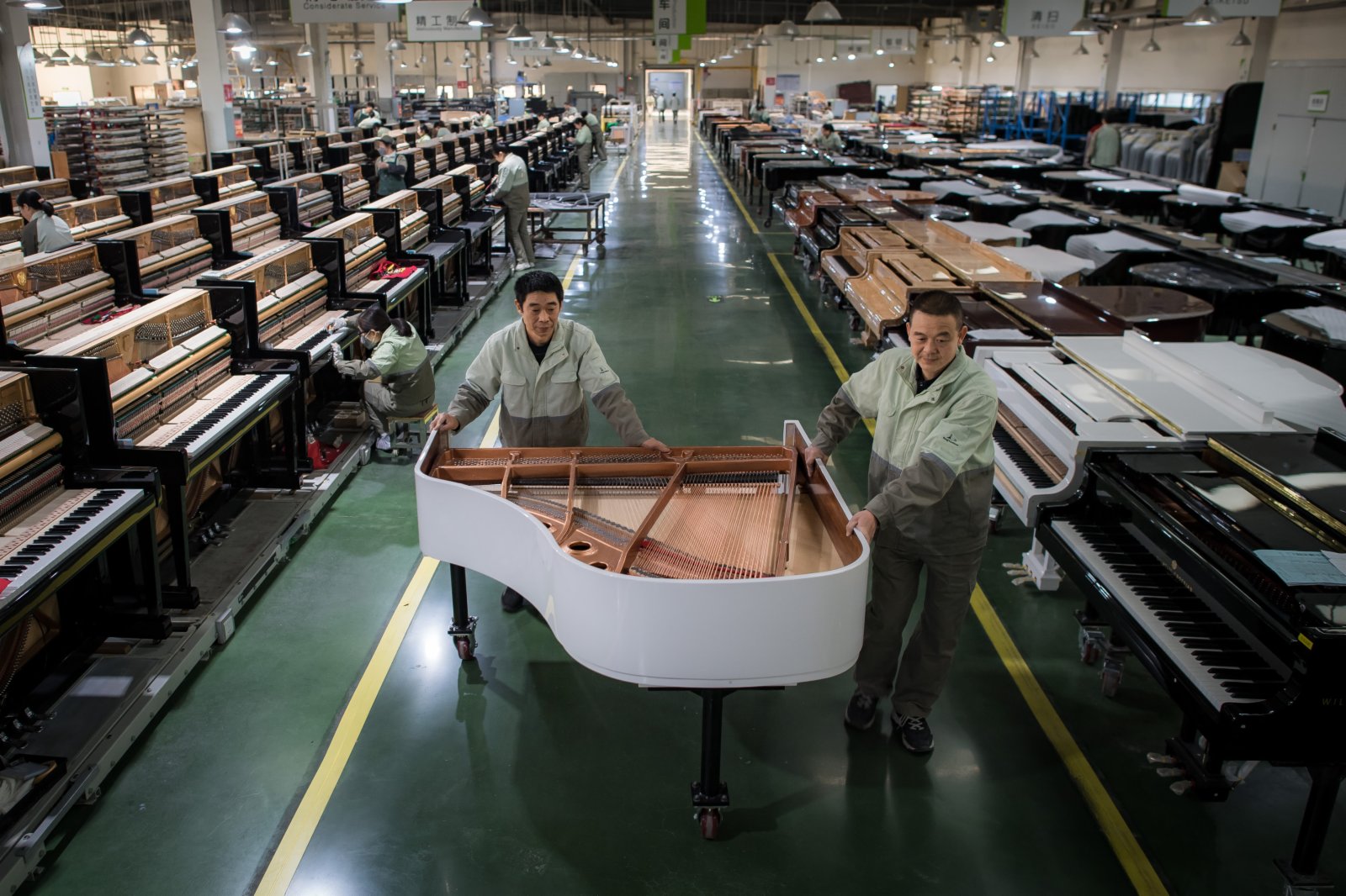 工人在柏斯音樂集團宜昌鋼琴生產基地搬運鋼琴。（新華社）