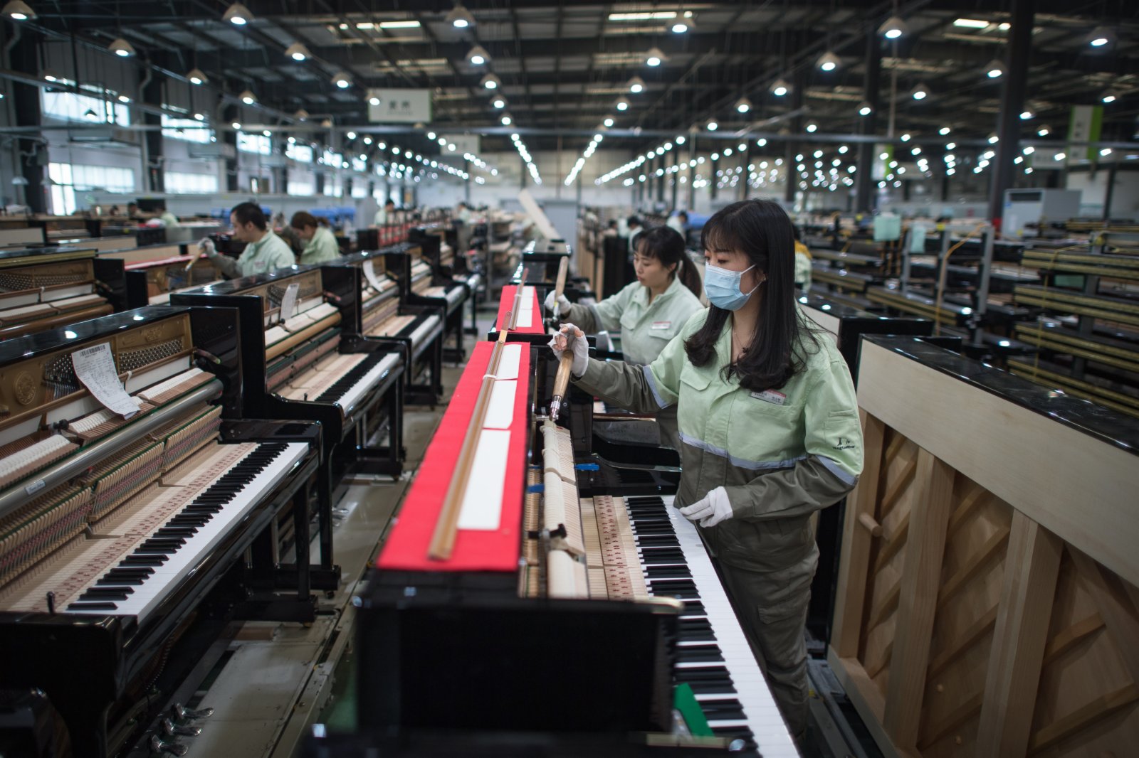 工人在柏斯音樂集團宜昌鋼琴生產基地調試鋼琴。（新華社）