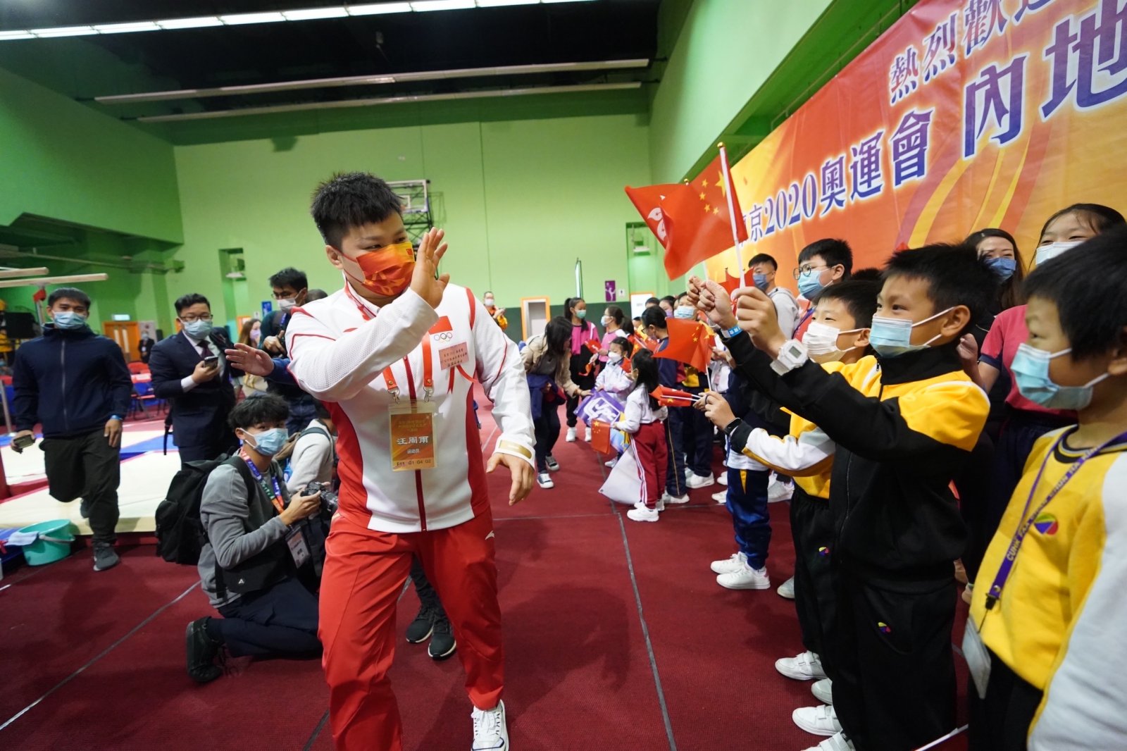 內地奧運健兒代表團成員汪周雨與小朋友互動。（新華社）