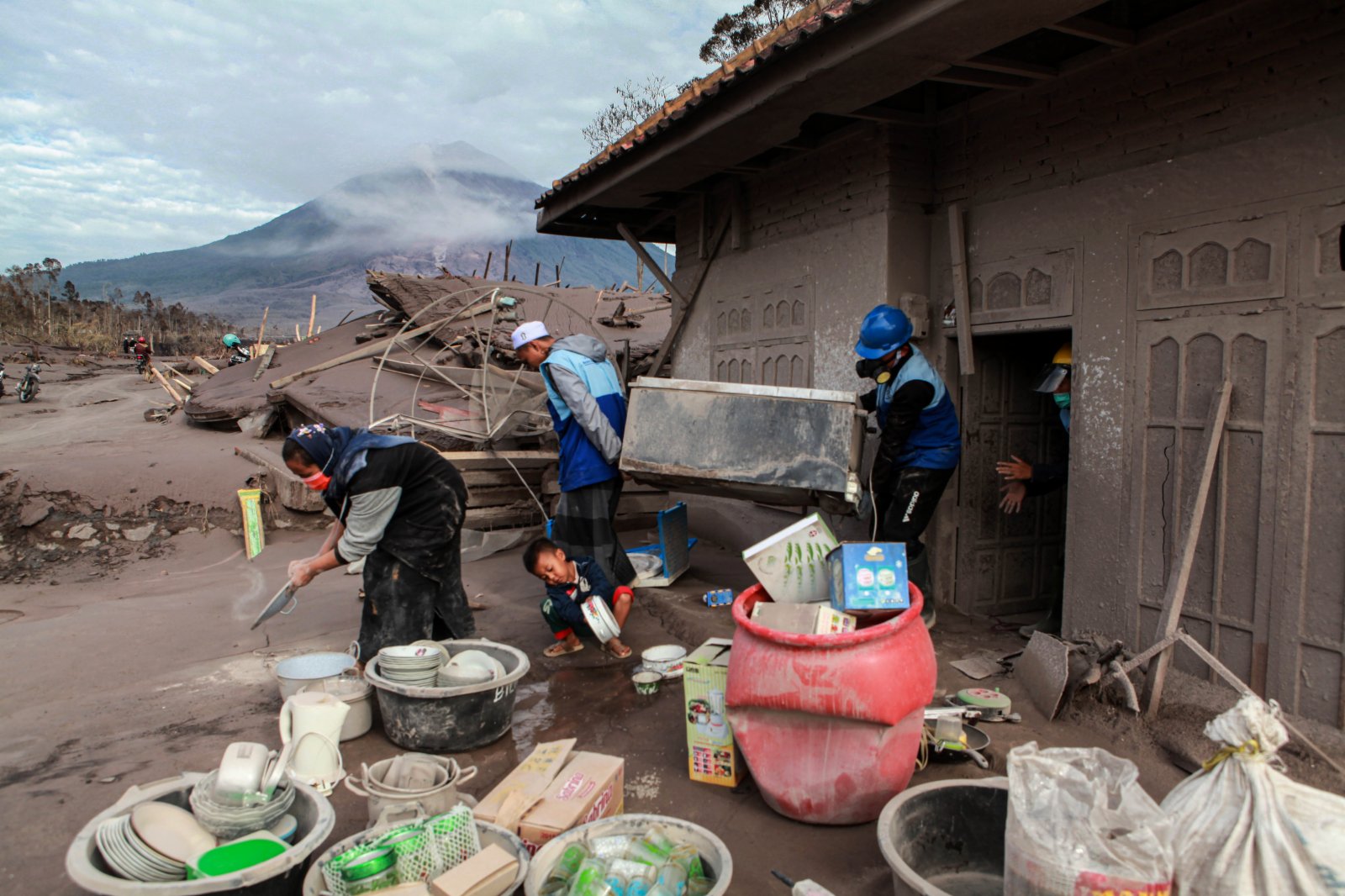 12月7日，在印度尼西亞東爪哇省盧馬姜，人們清理被火山灰覆蓋的物品。（新華社）
