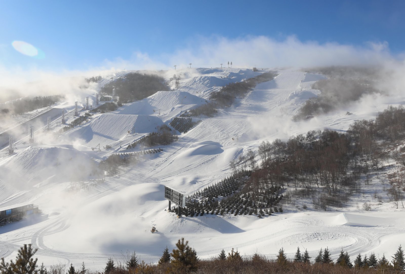  12月17日，雲頂滑雪公園的工作人員操作機械設備在賽道上工作。（新華社）