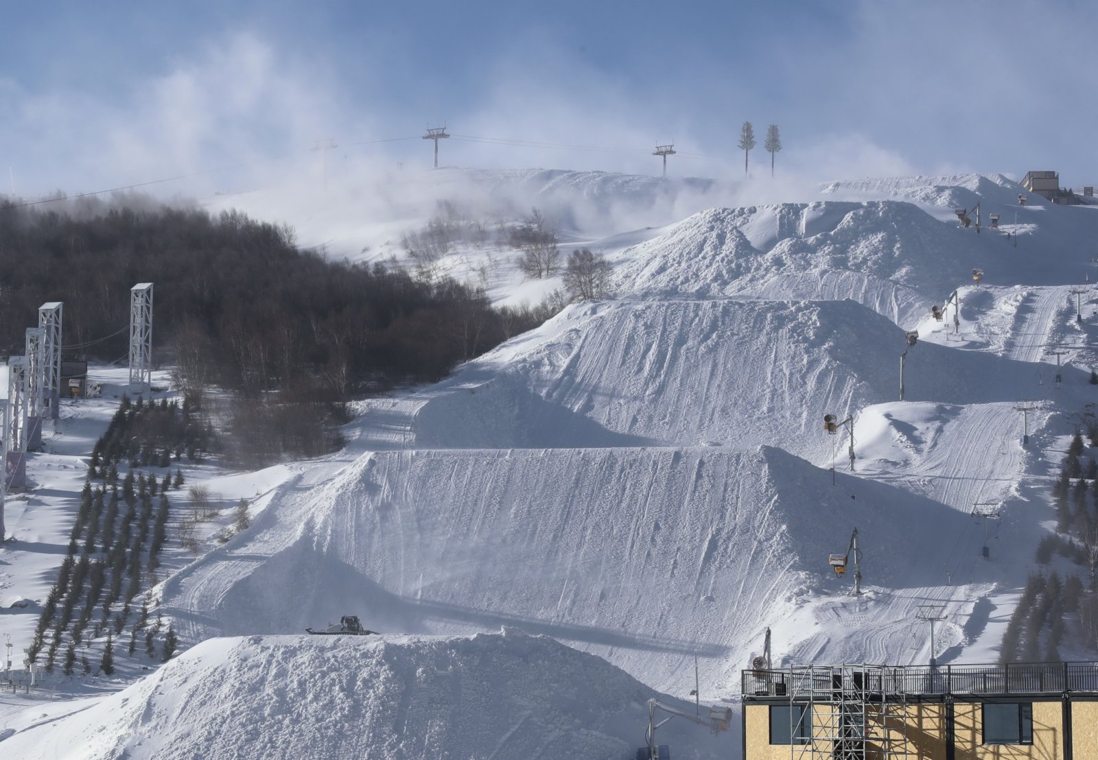 12月17日，雲頂滑雪公園的工作人員操作機械設備在對賽道塑型。（新華社）