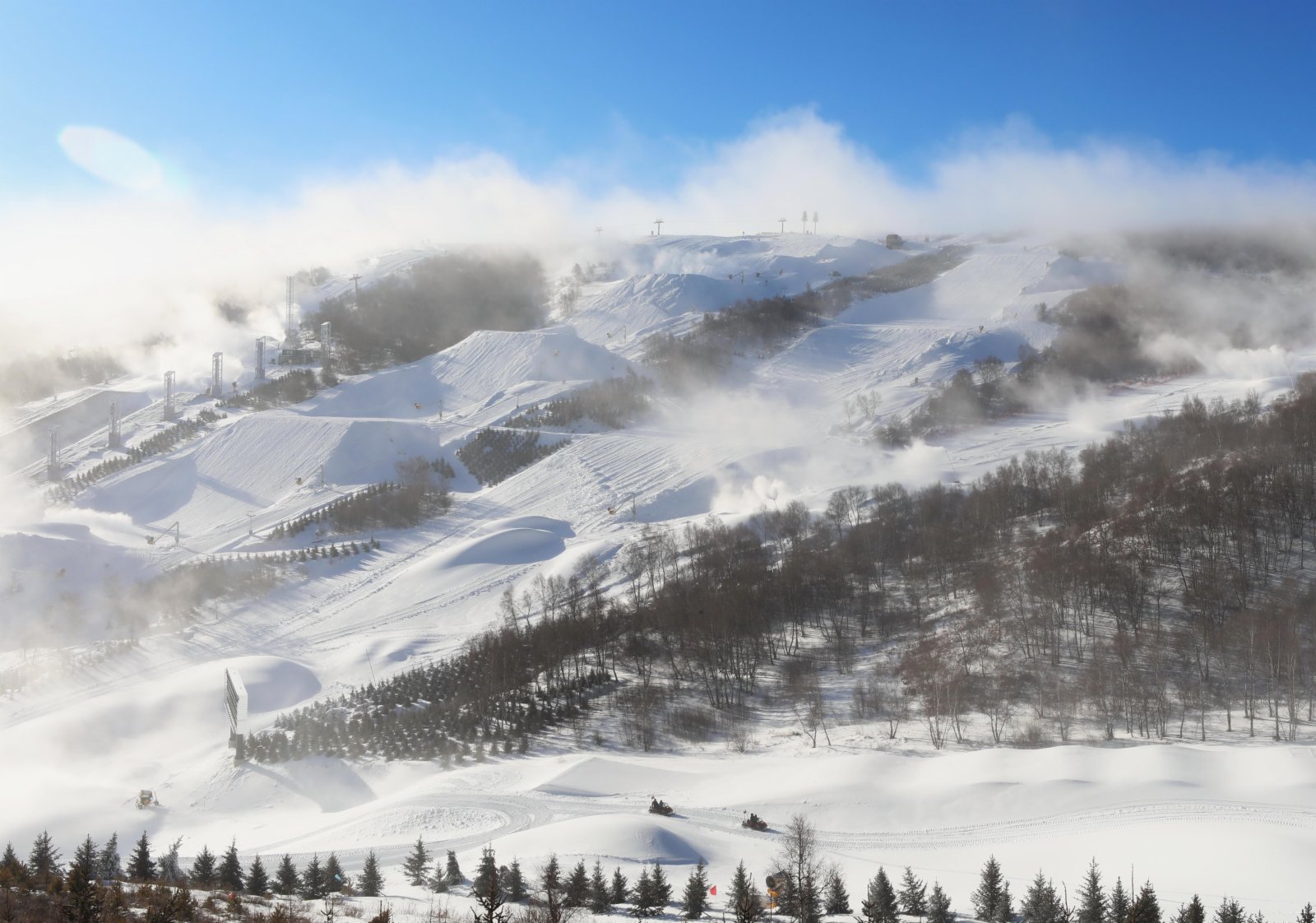 12月17日，工作人員駕駛雪地摩托從雲頂滑雪公園的一條賽道旁通過。（新華社）