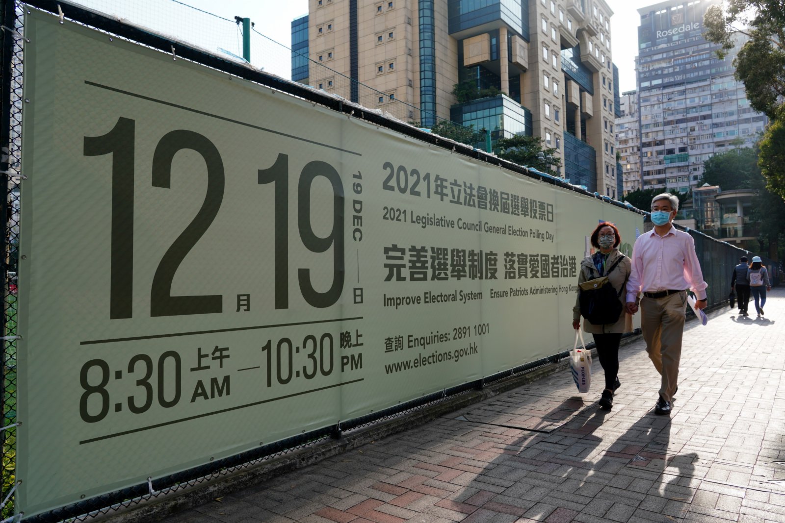 12月18日，市民從香港銅鑼灣街頭的立法會選舉宣傳廣告前經過。（中新社）