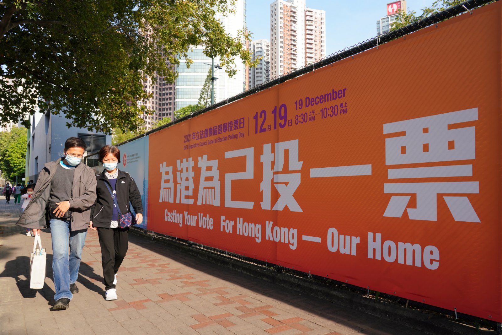 12月18日，市民從香港銅鑼灣街頭的立法會選舉宣傳廣告前經過。（中新社）