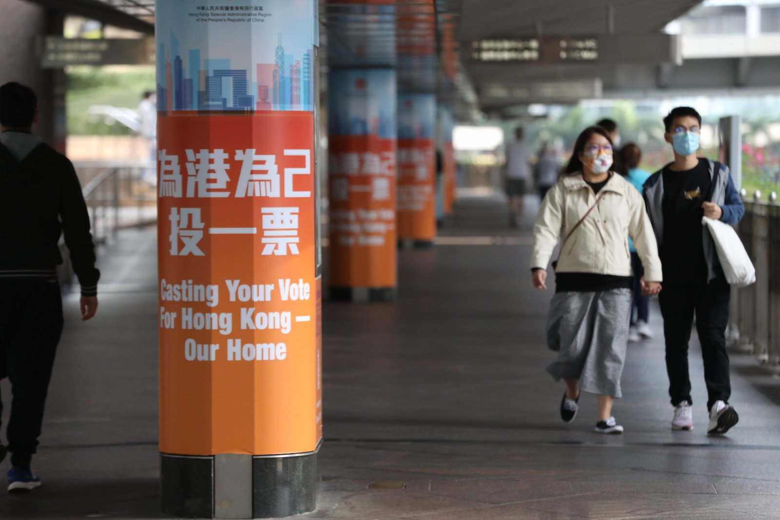 12月18日，市民從街頭的立法會選舉宣傳廣告旁經過。（香港文匯報）