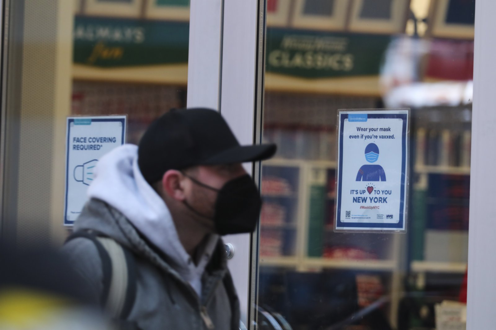 1月4日，行人從美國紐約一家貼着防疫標識的商店外走過。（新華社）