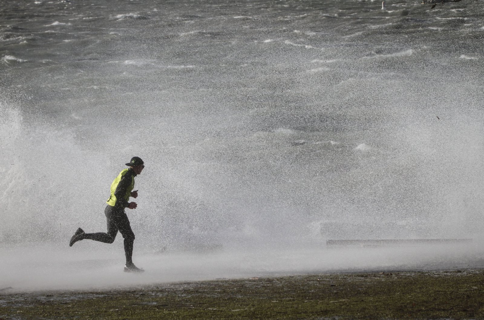 1月7日，在加拿大溫哥華，一名男子在英吉利灣的風浪中跑步。（新華社）