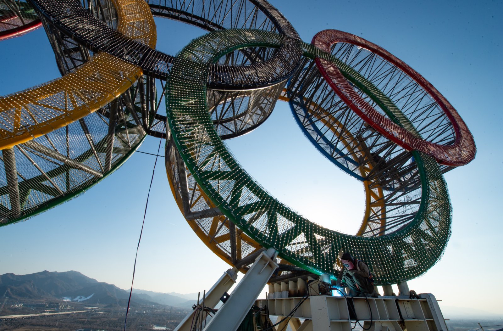 1月11日，工人們在「海陀塔」塔頂的奧運五環標誌下作業。
