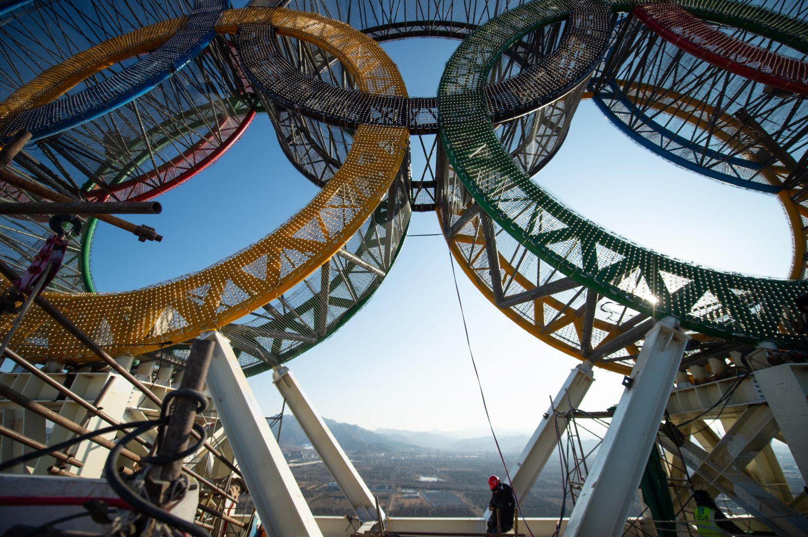 1月11日，工人們在「海陀塔」塔頂的奧運五環標誌下作業。