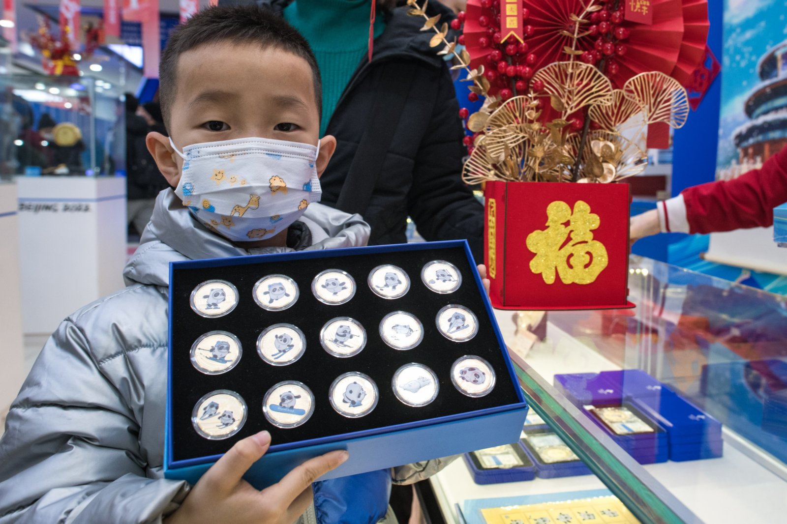 1月12日，一名小朋友展示購買的冬奧紀念品。（新華社）