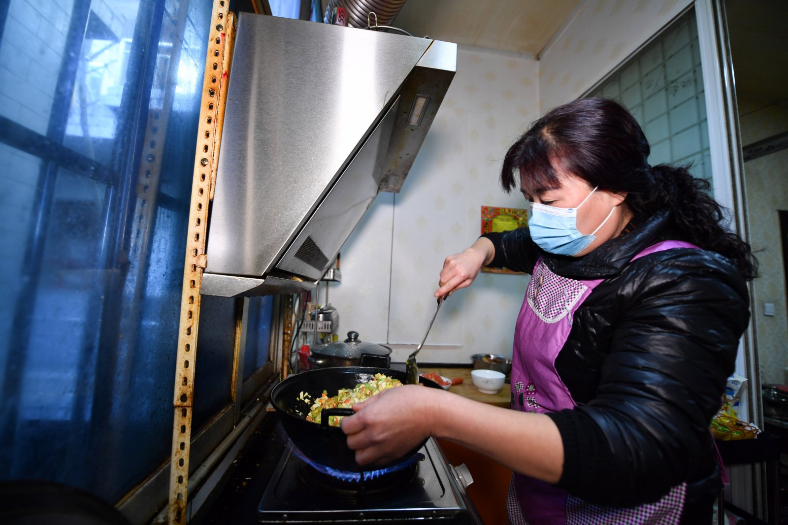 1月12日，三家村村民周娟為租住在自家房屋的居民製作午餐。（新華社）