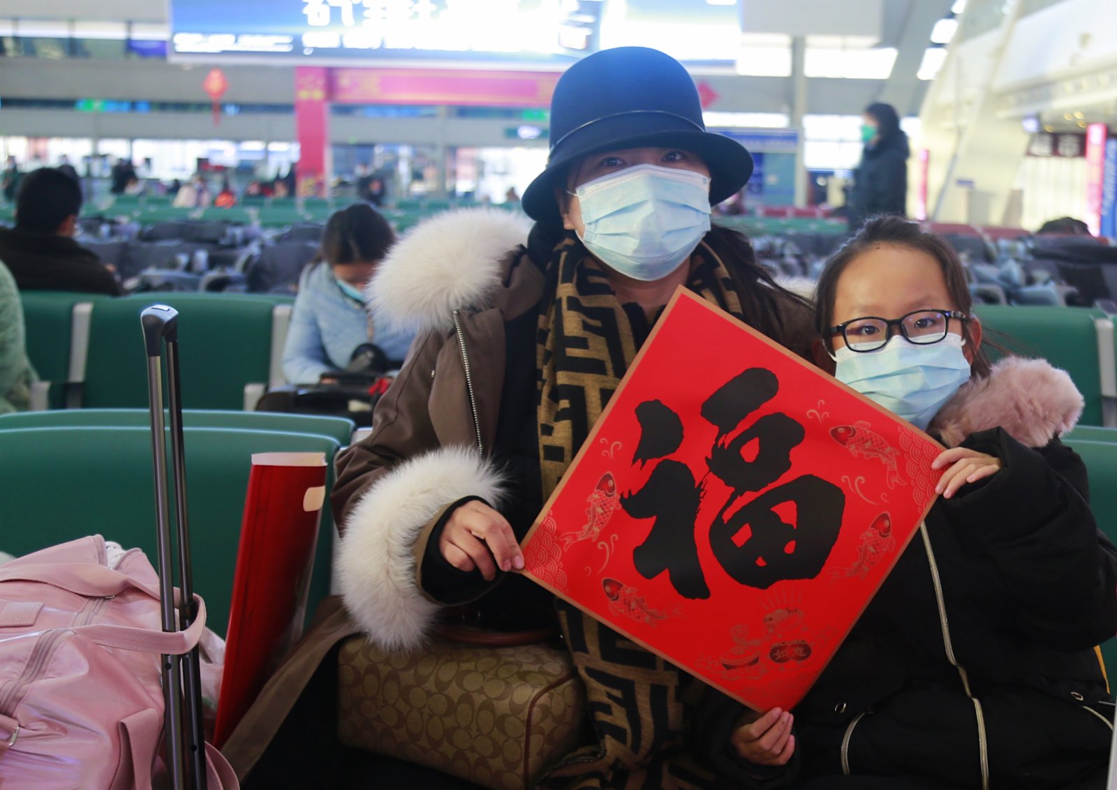 1月17日，在青海省西寧市西寧火車站候車大廳內的旅客手拿「福」字迎新年。（中新社）