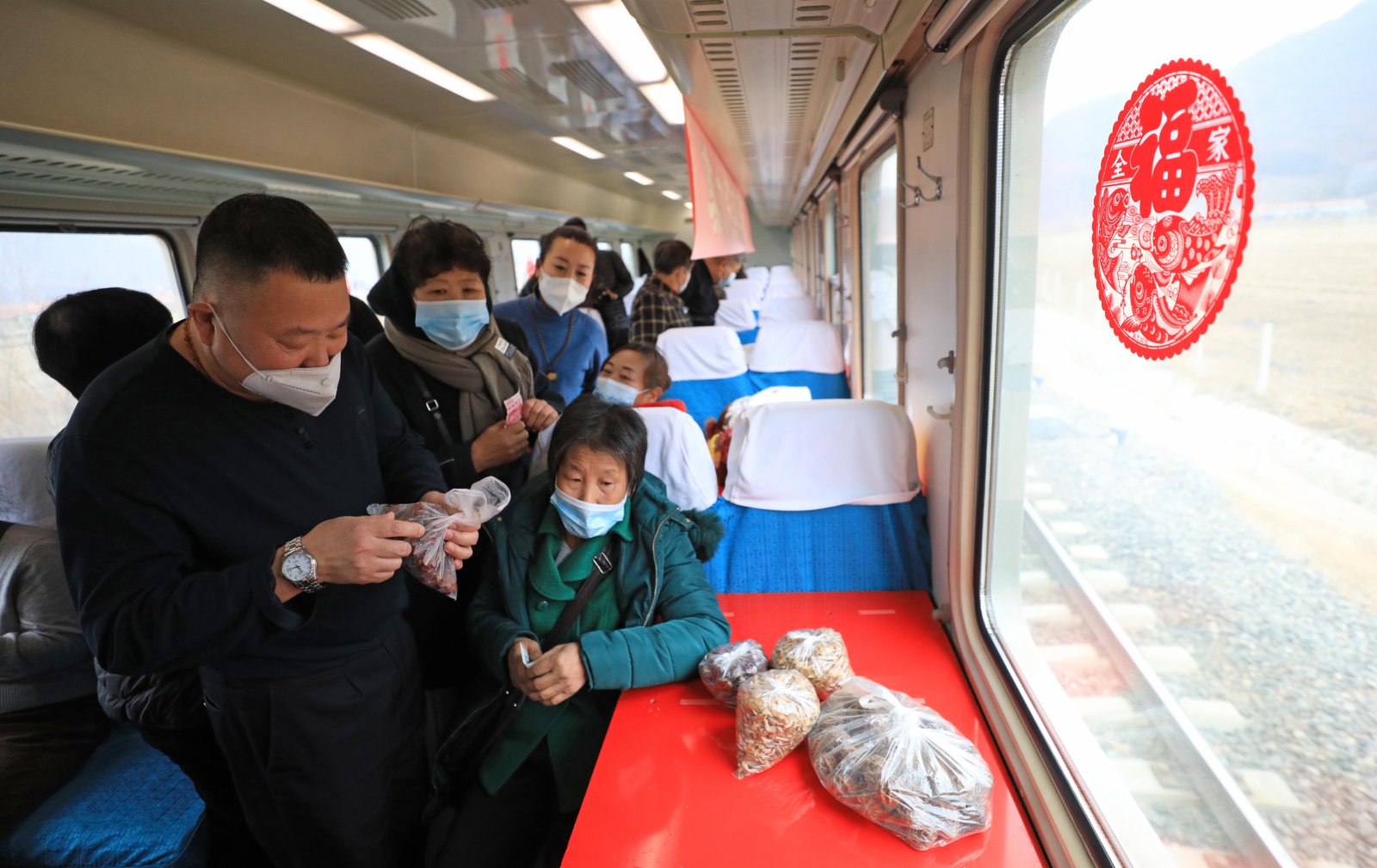 1月15日，在4318次列車上，旅客購買各種山貨。（新華社）