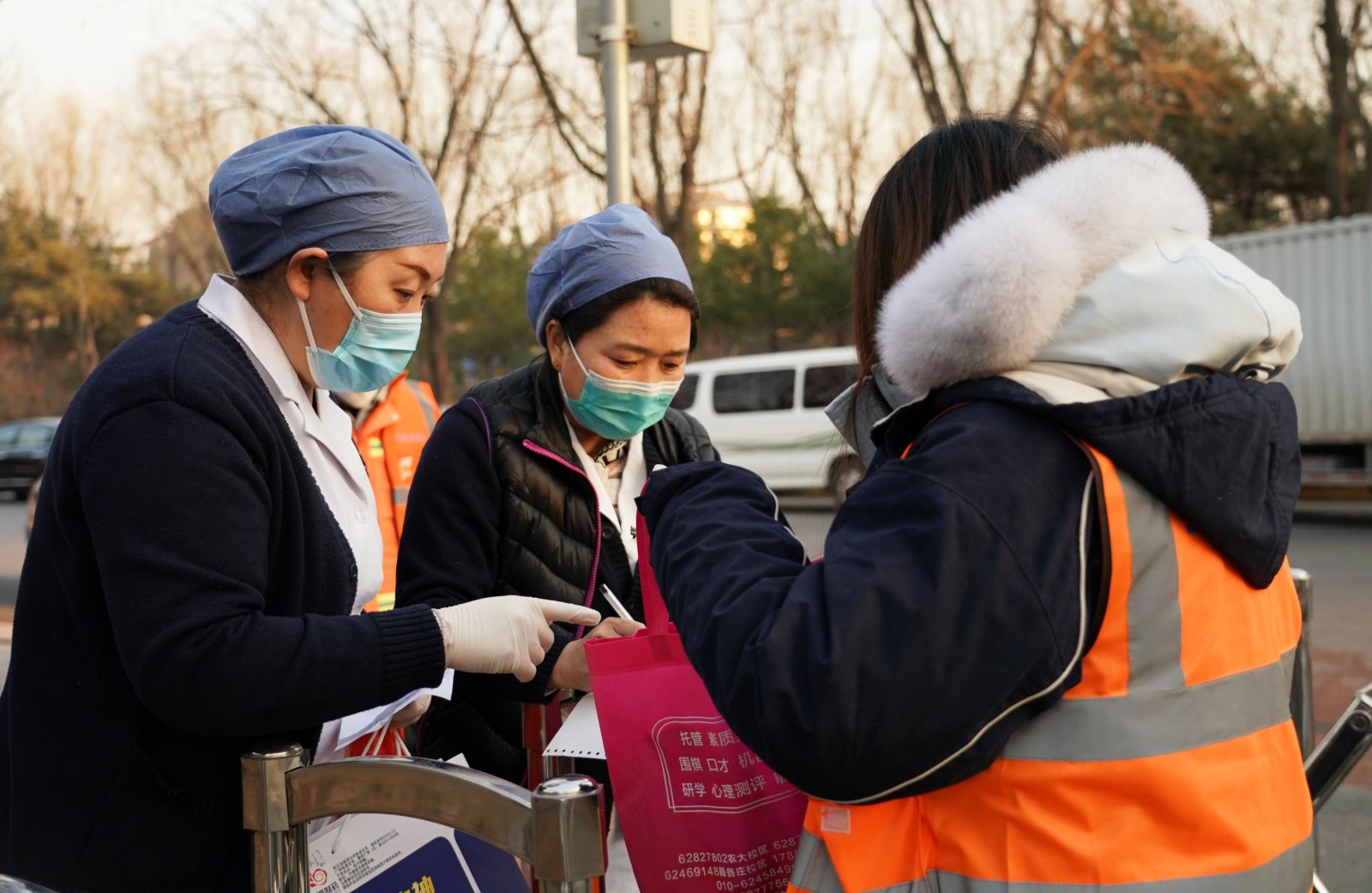 1月18日，在百旺茉莉園一期外，馬連洼社區衛生服務中心的醫護人員為行動不便的老人代領藥物並送到社區門口。（新華社）