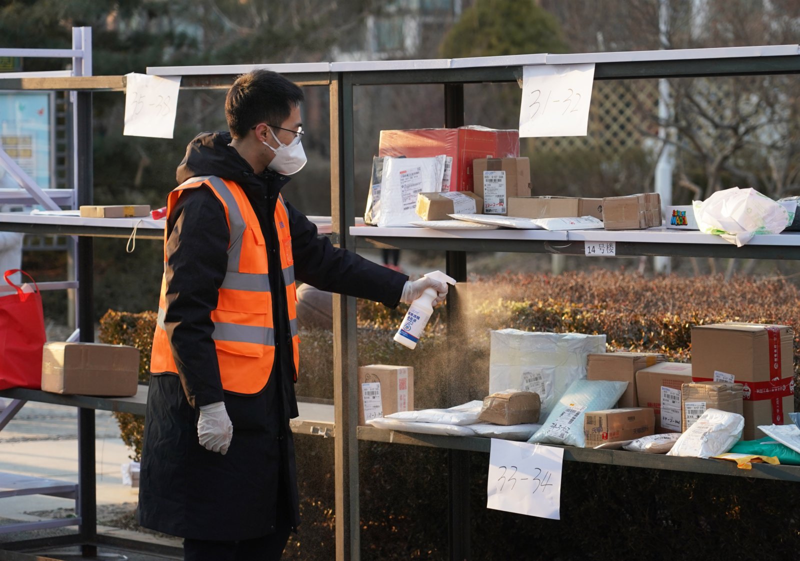 1月18日，在百旺茉莉園一期外，工作人員對快遞進行消毒。（新華社）